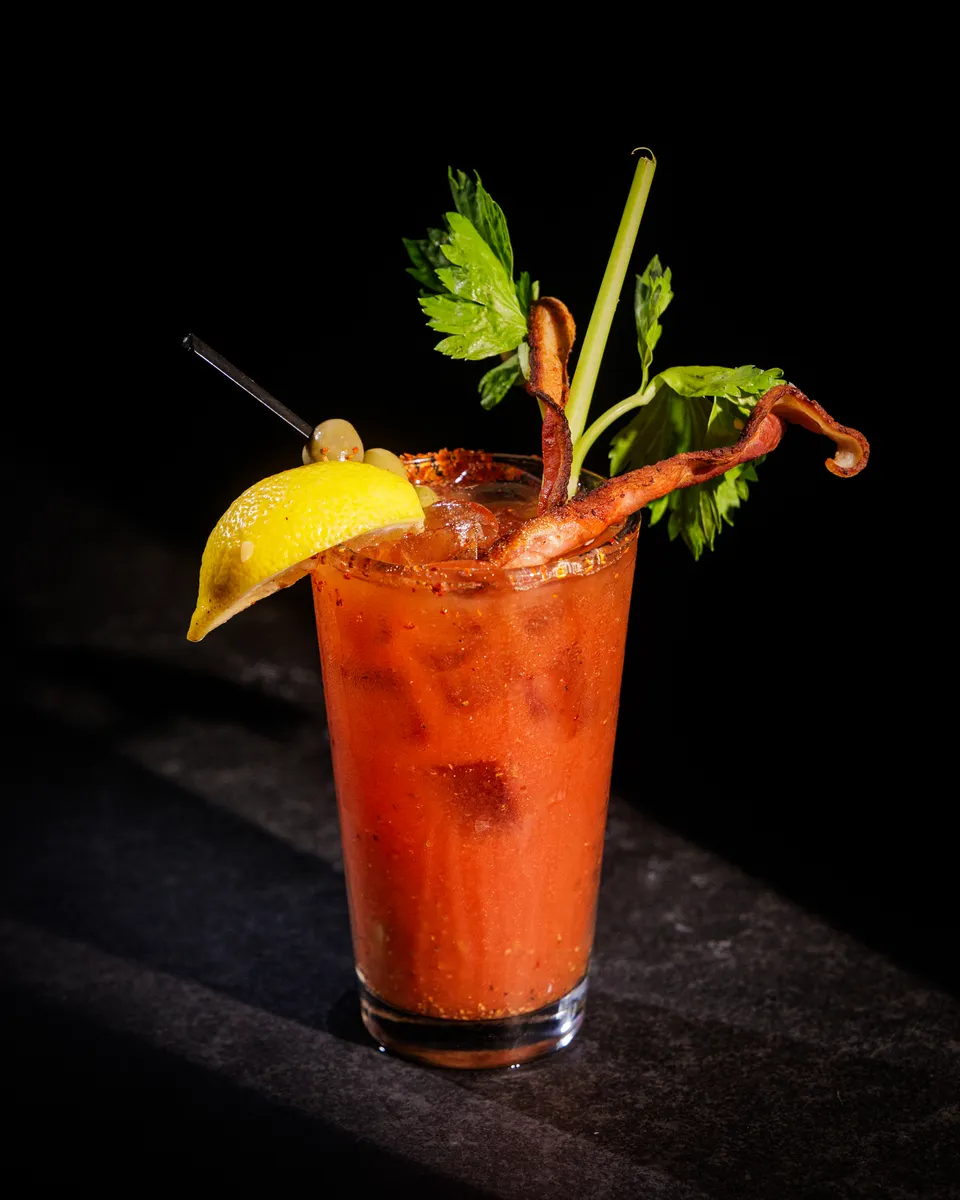 Bloody mary garnished with an octopus tentacle, celery, and lemon